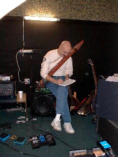Tony Levin with his Stick bass on, writes down last minute changes. 